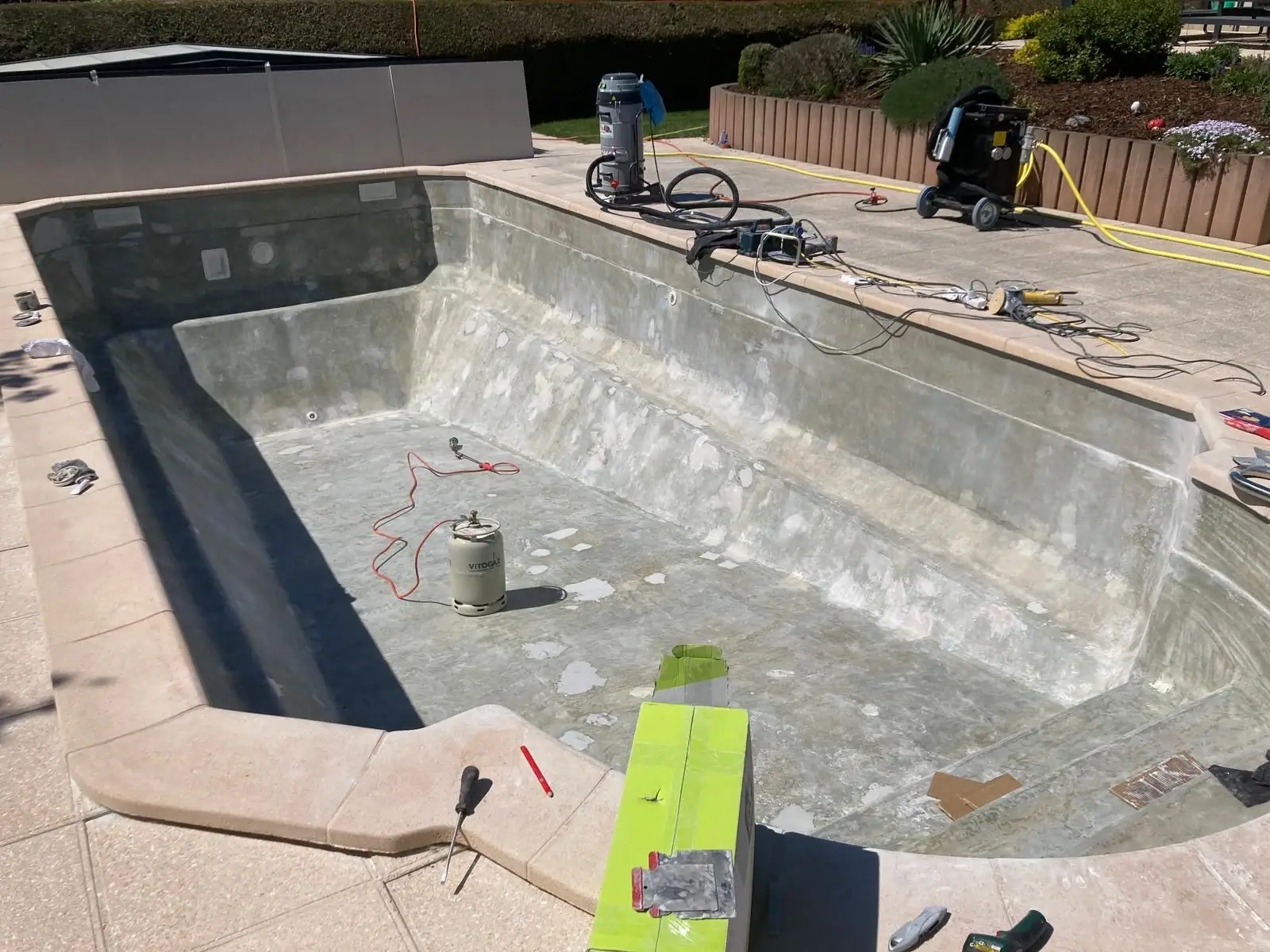 Balai et produits de traitement pour piscine en cours d'installation.