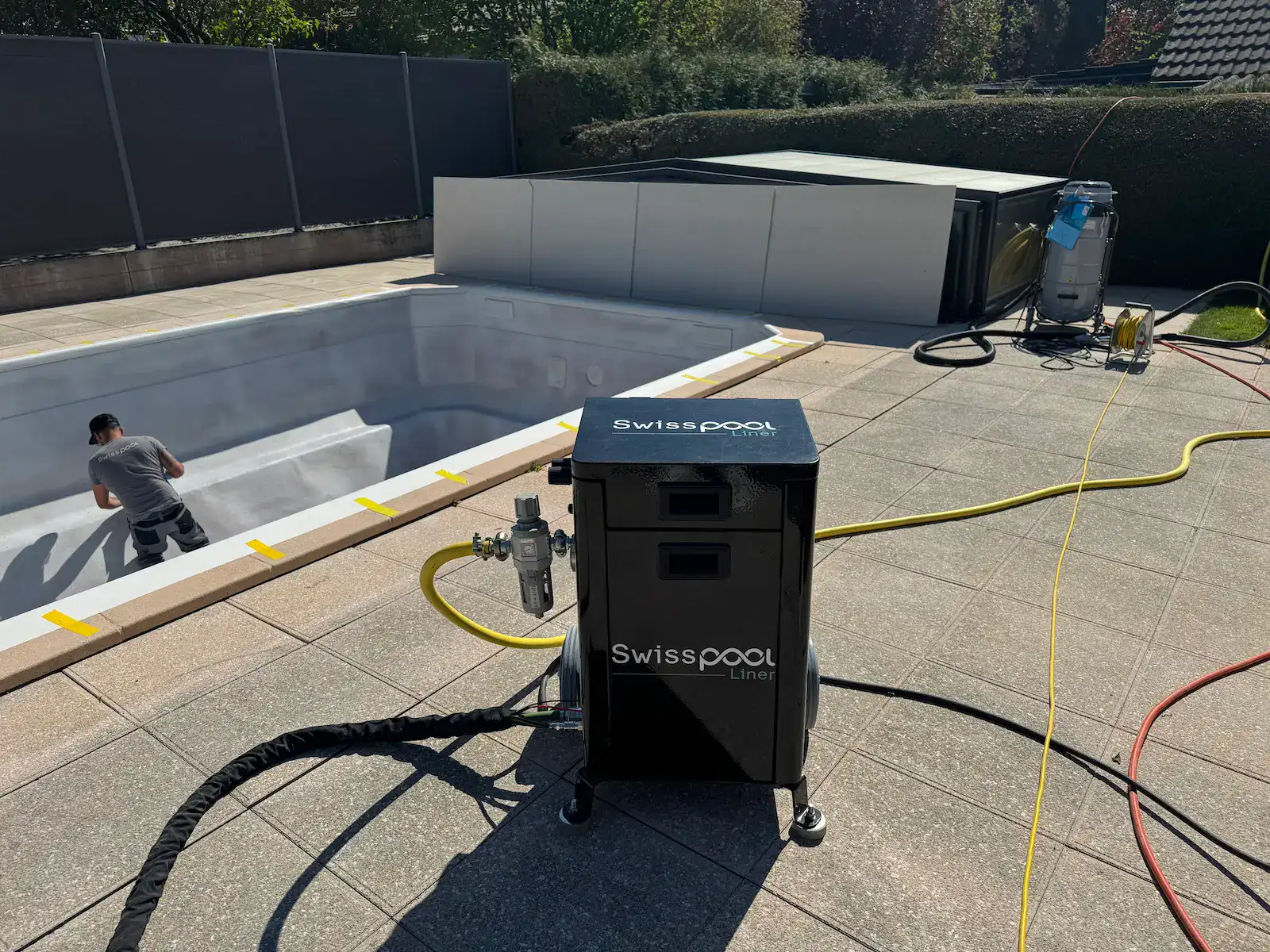 Pistolet à peinture pour liner de piscine installé à l'extérieur.